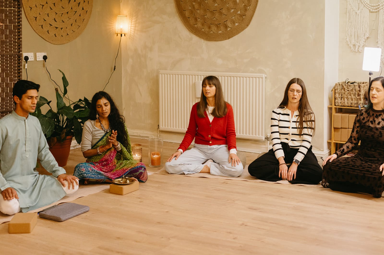 Yogi Madhav and a teacher lead trainees in seated meditation