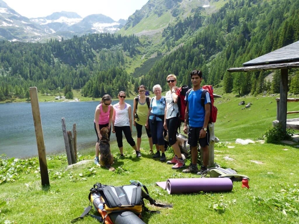 The retreat group with hiking gear beside an alpine lake