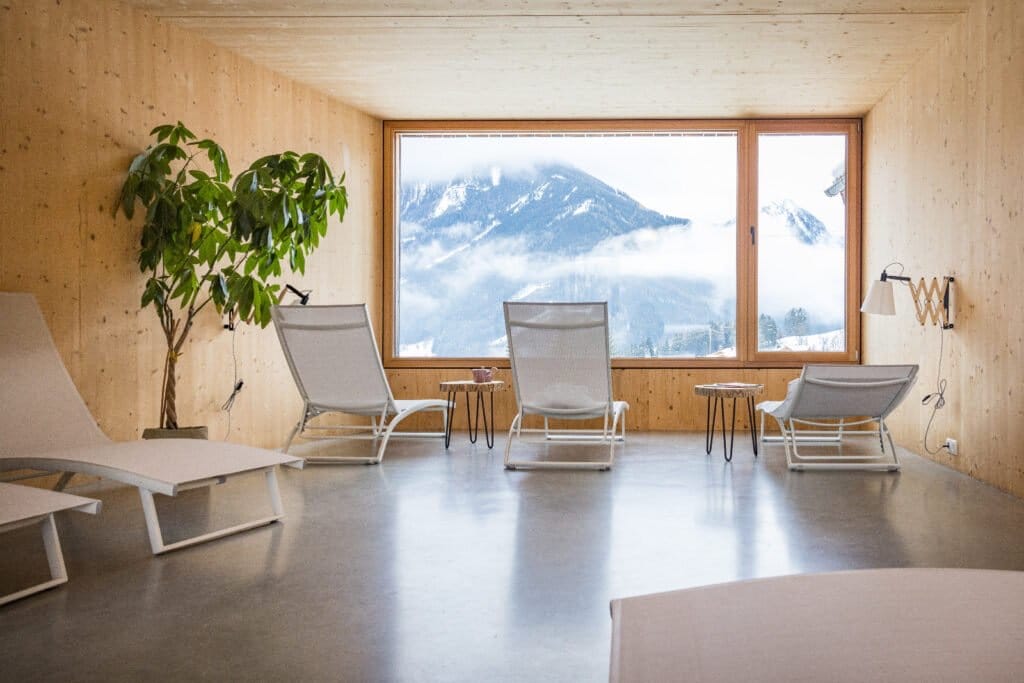 Relaxation room with loungers and a panoramic window onto the mountains