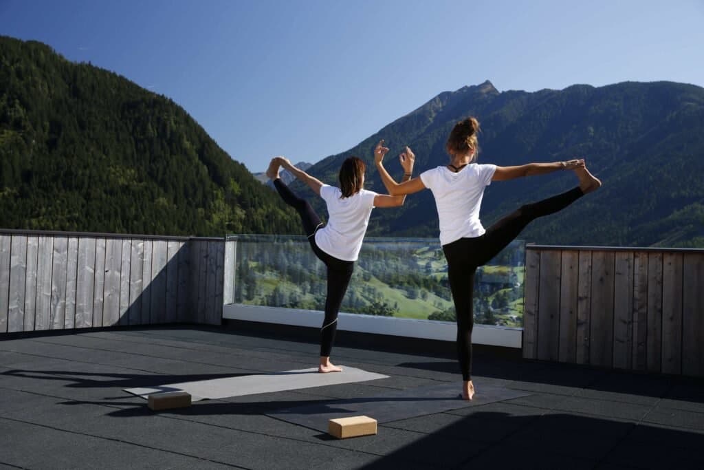 Two women in dancer pose on the rooftop terrace