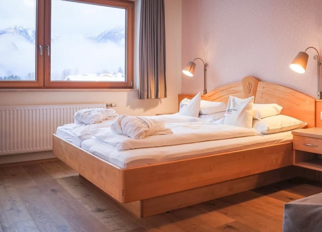Double room with wooden furnishings and balcony doors