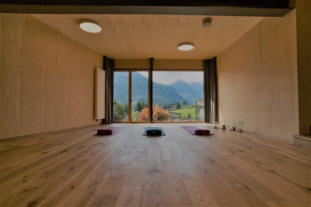 Timber yoga studio with floor-to-ceiling windows onto the mountains