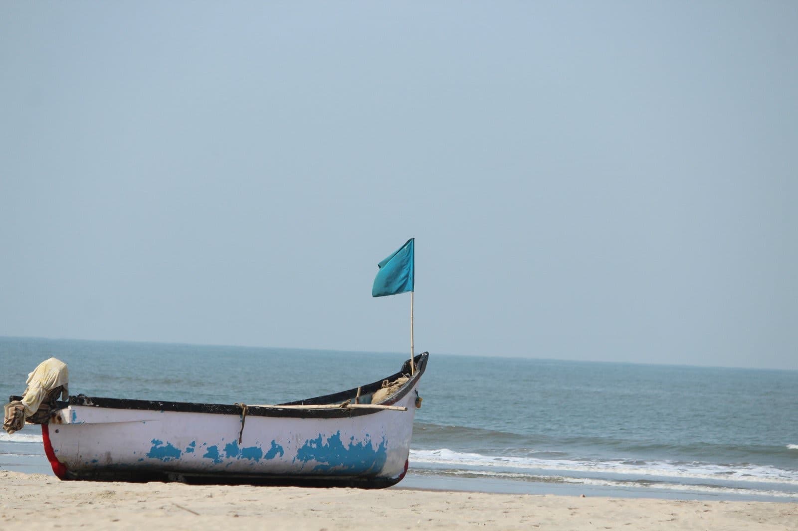 A traditional wooden fishing boat resting on the sand