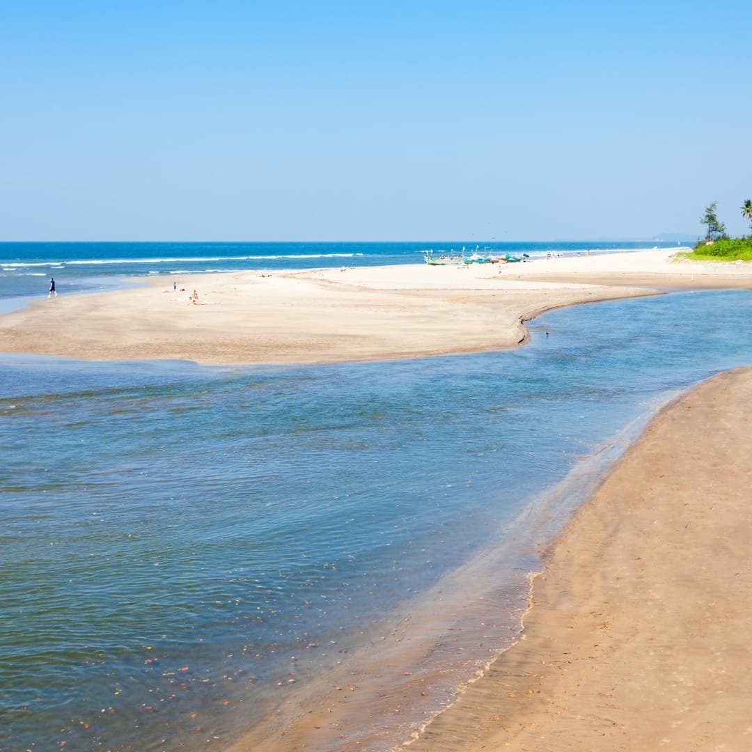 A river meeting the sea beside a sandbank